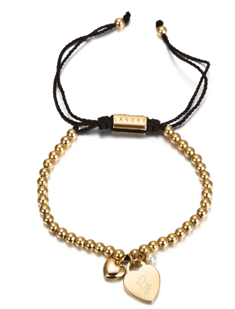 Bracelet doré avec un pendentif en forme de cœur gravé